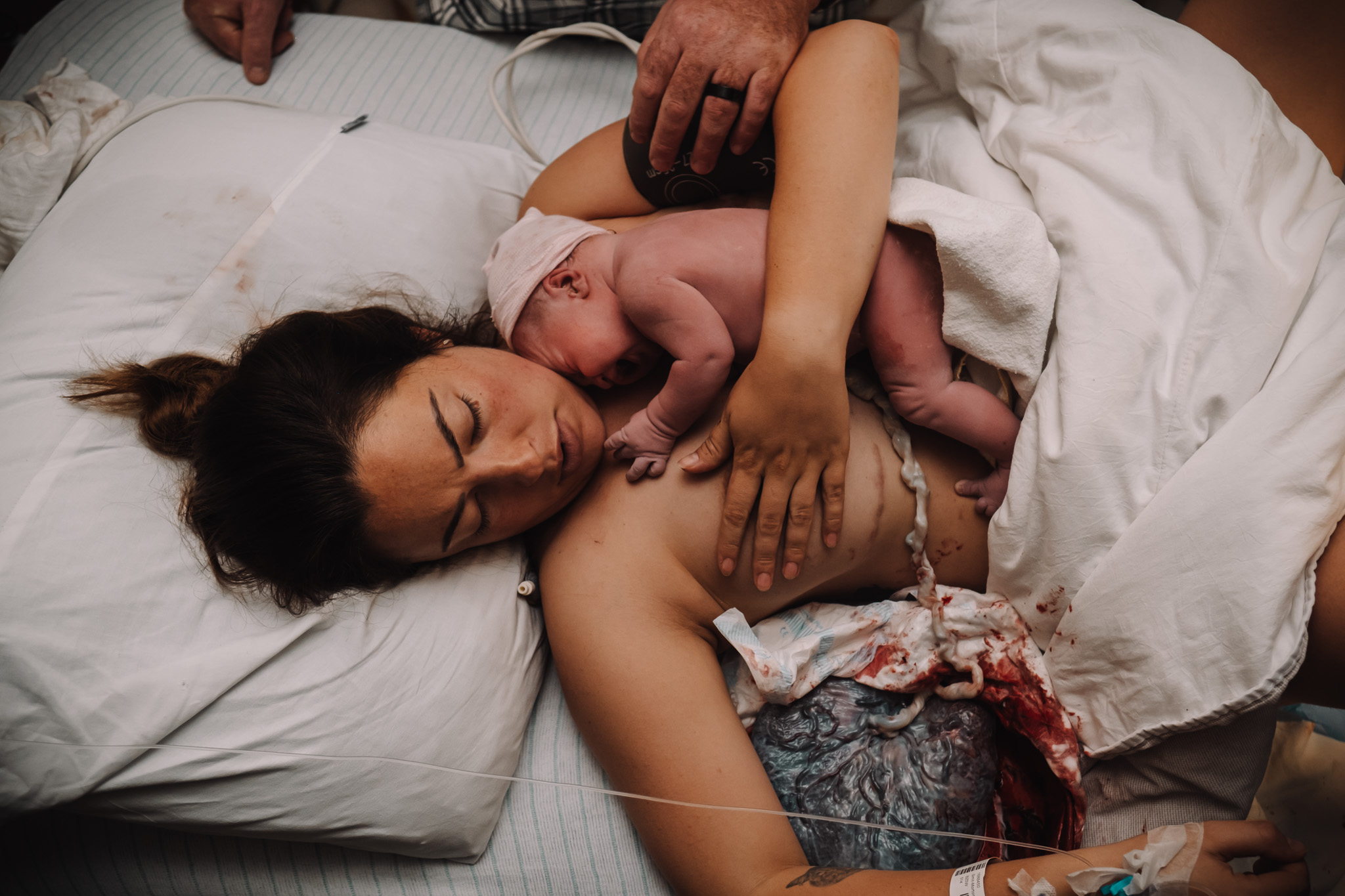 Mom with baby in arms, still attached to placenta