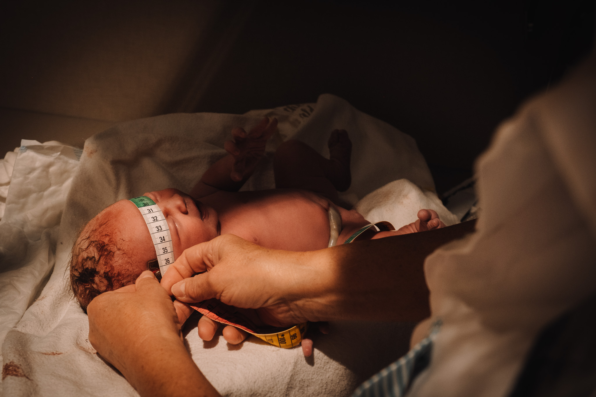 newborn having head measured